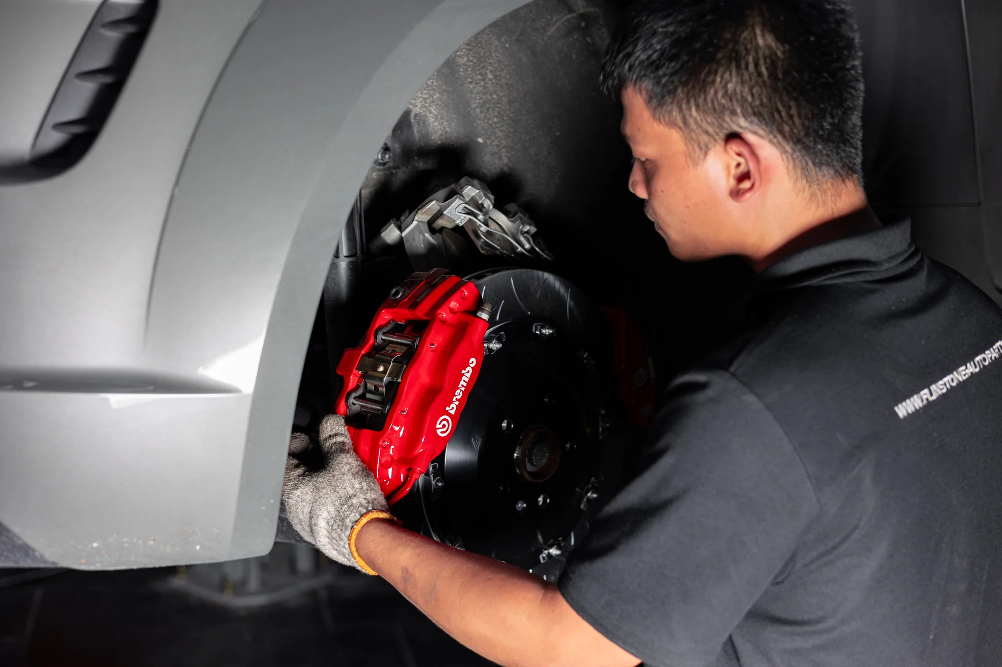 ช่าง Flinstone Autoparts กำลังติดตั้งคาลิเปอร์ Brembo สีแดง