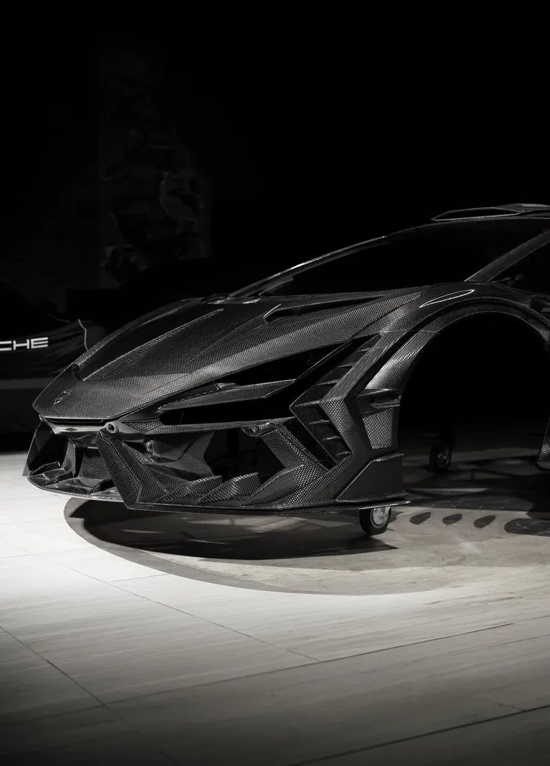 Low-angle view of the carbon fiber front bumper on a Lamborghini Revuelto, TOPCAR R’Evo Carbon Edition