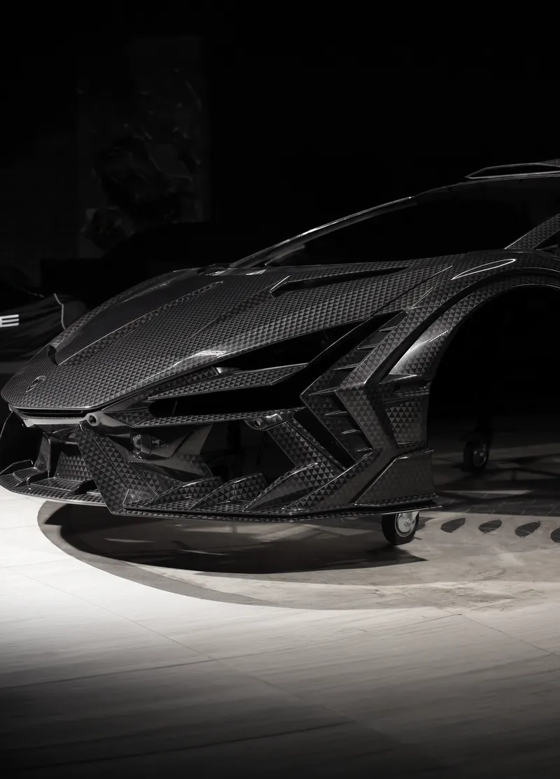 Low-angle view of the carbon fiber front bumper on a Lamborghini Revuelto, TOPCAR R’Evo Stealth Edition