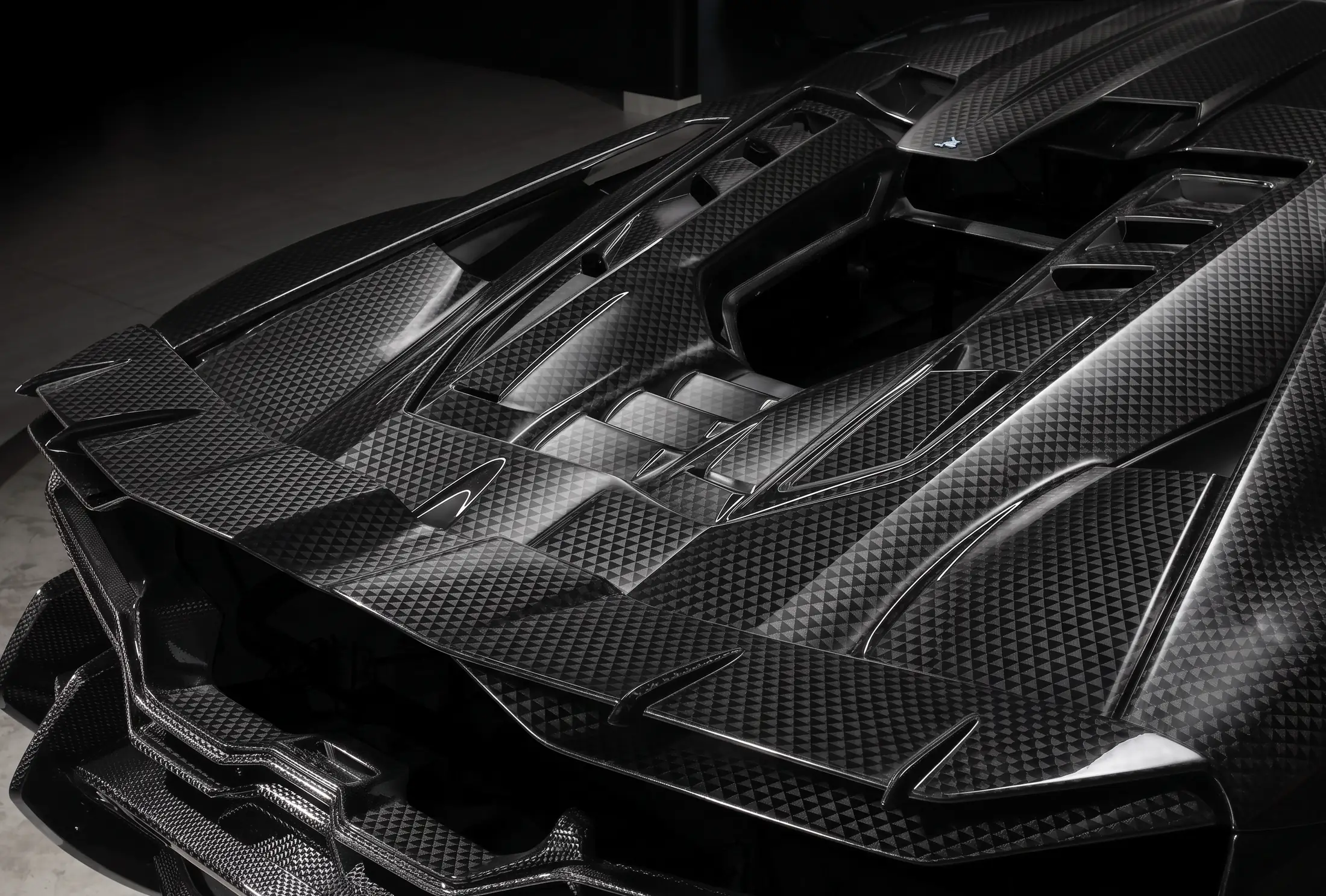 Close-up of the carbon fiber engine cover on a Lamborghini Revuelto with TOPCAR R’Evo Stealth Edition body kit